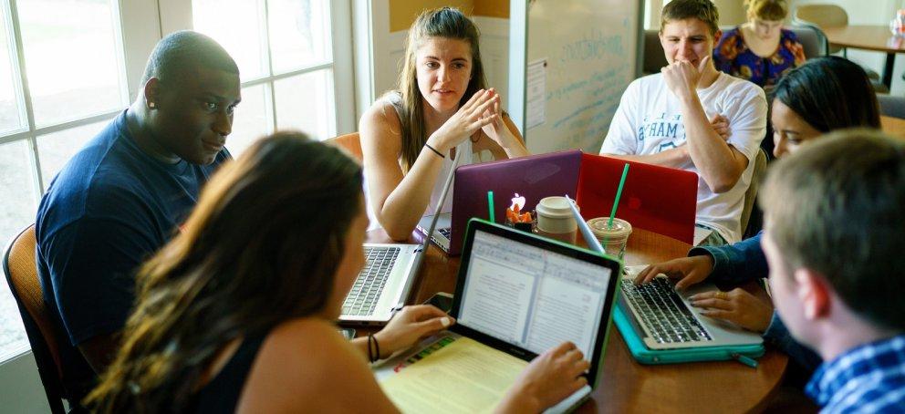 Writers and a Writing Circle Facilitator discussing a paper in the Writing Center.